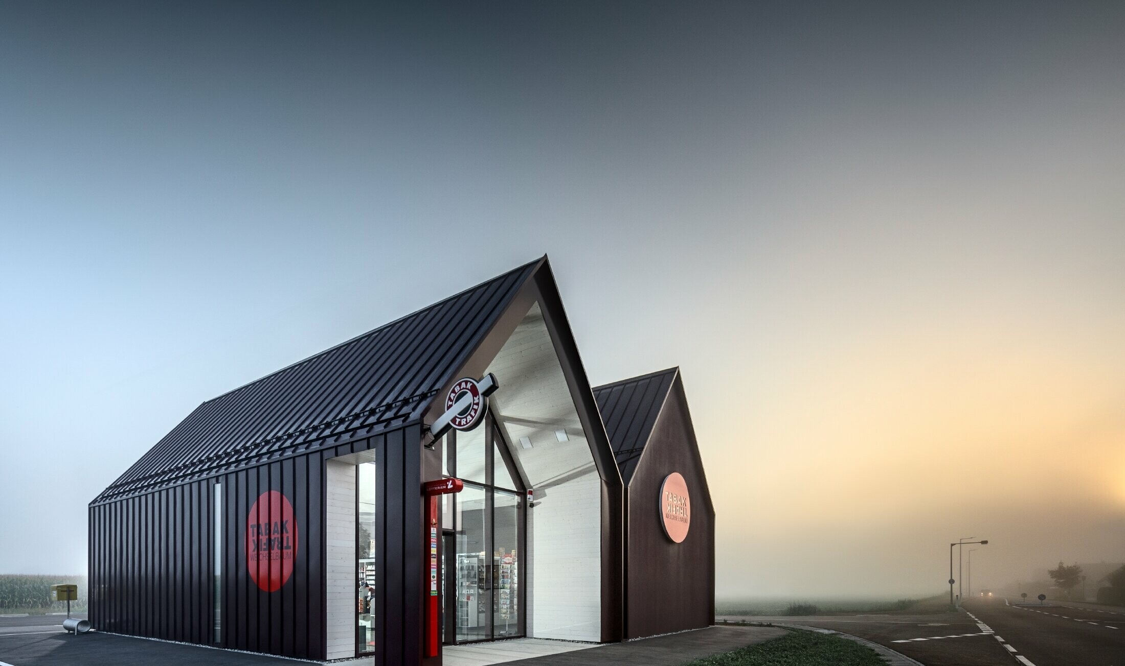 Modern tobacconist with gable roof (without overhanging eaves) and an aluminium coating by PREFA with standing and single lock standing seam in the special colour of black red