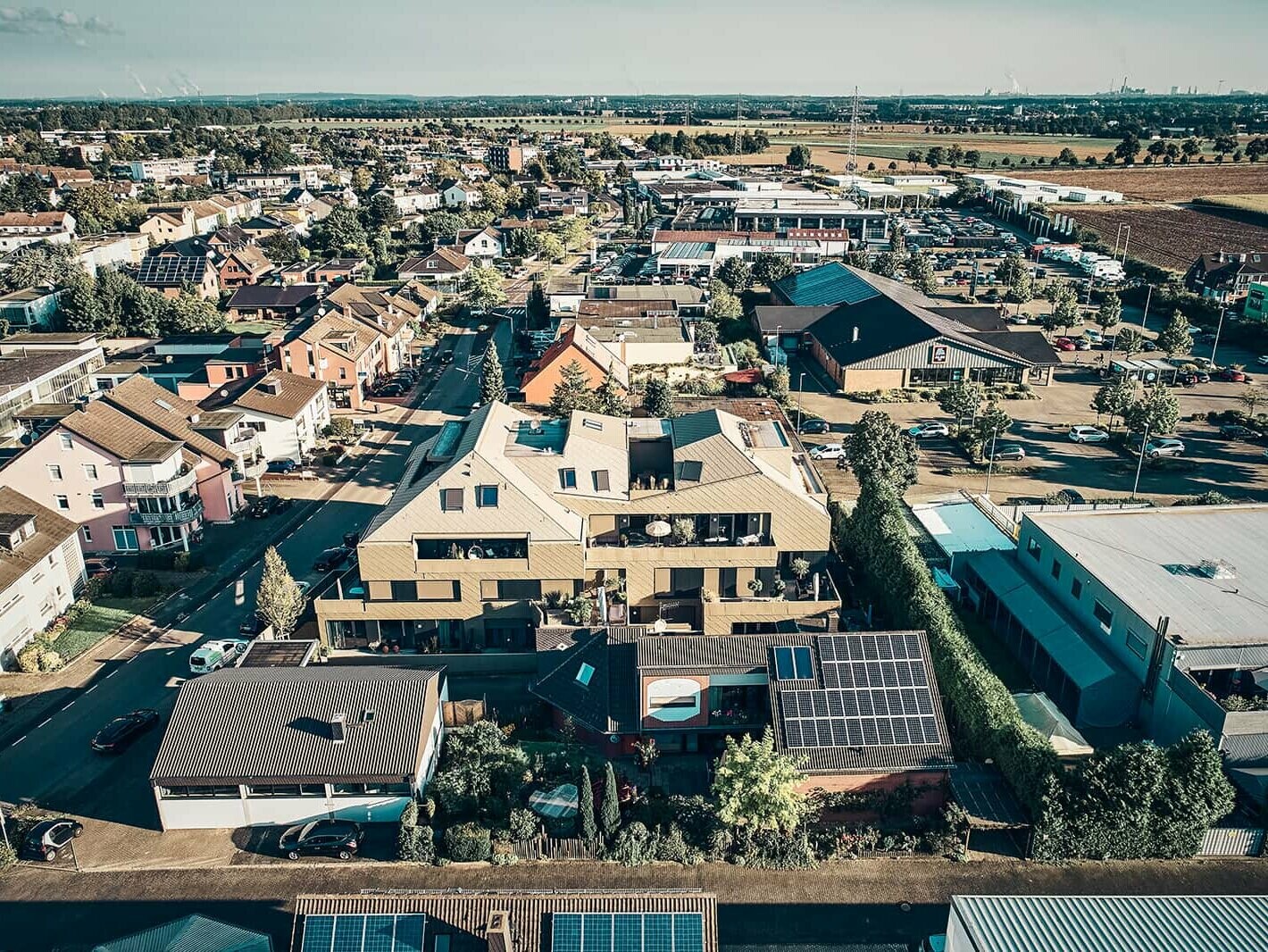 Bird's eye view of the Erftstadt residential building with the clearly recognisable rhomboide façade and the P.10. bronze roof tiles by PREFA.