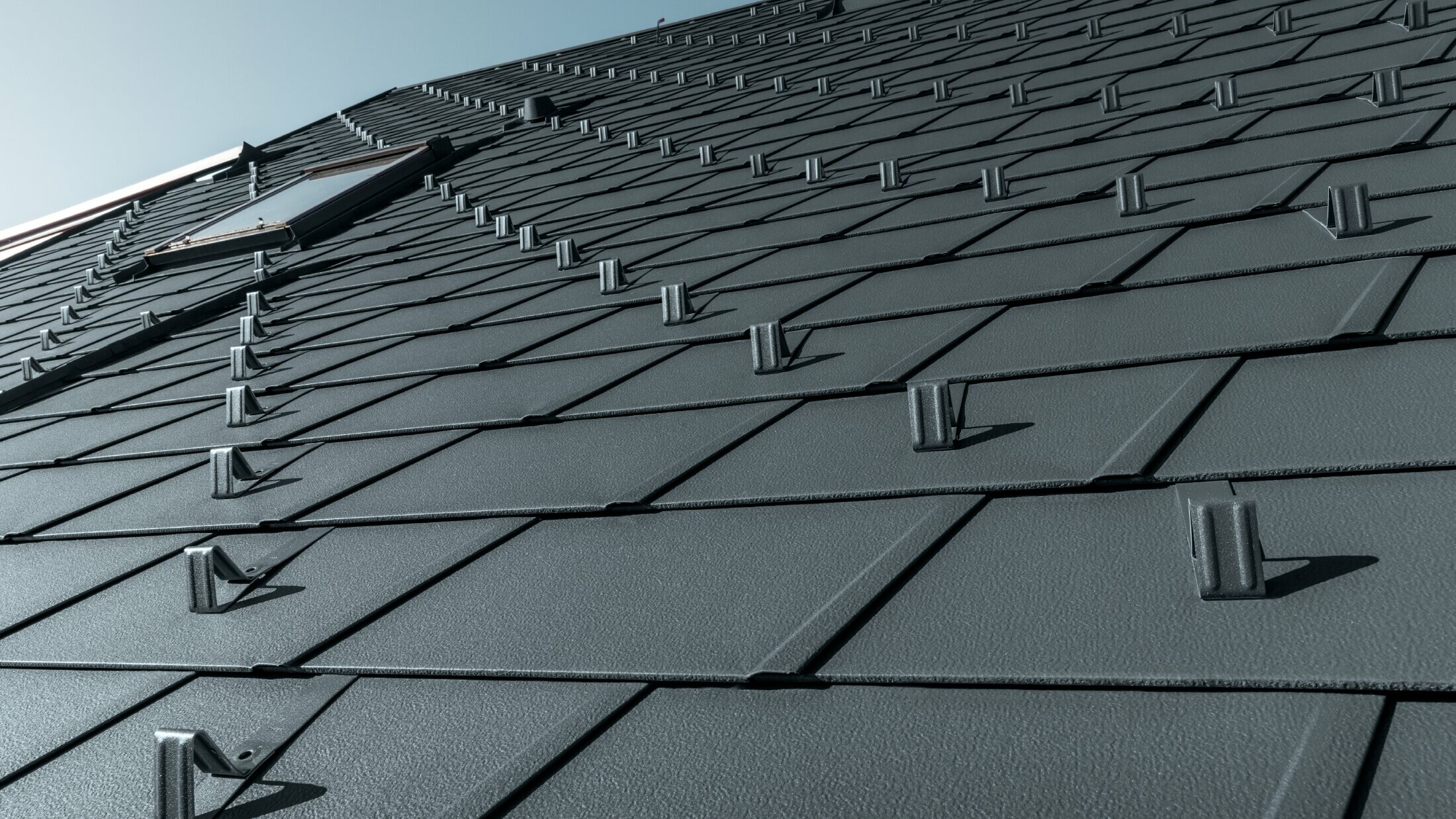 PREFA DS.19 roof shingle in P.10 anthracite with snow stoppers, dormer surrounds and chimney