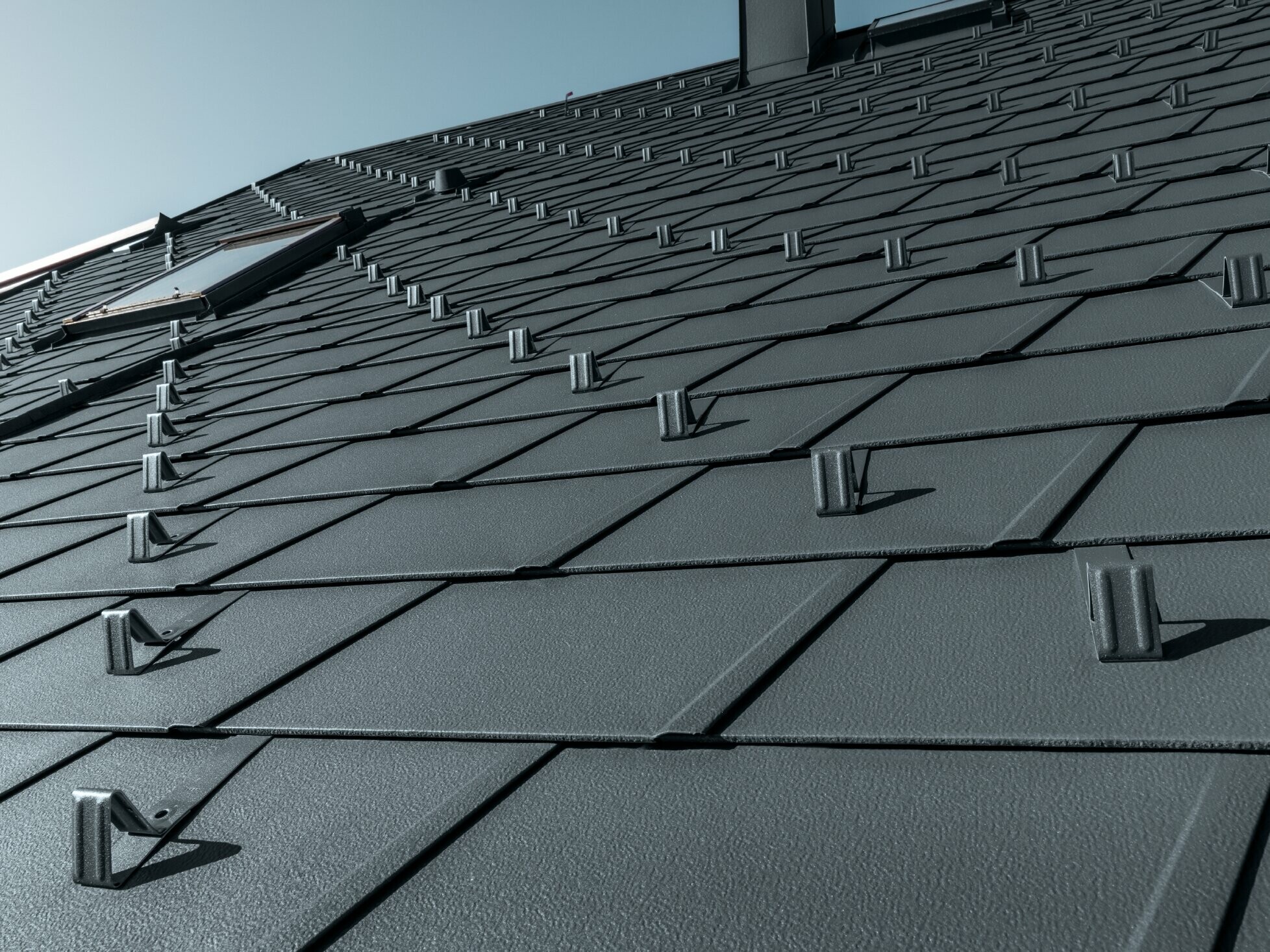 PREFA DS.19 roof shingle in P.10 anthracite with snow stoppers, dormer surrounds and chimney