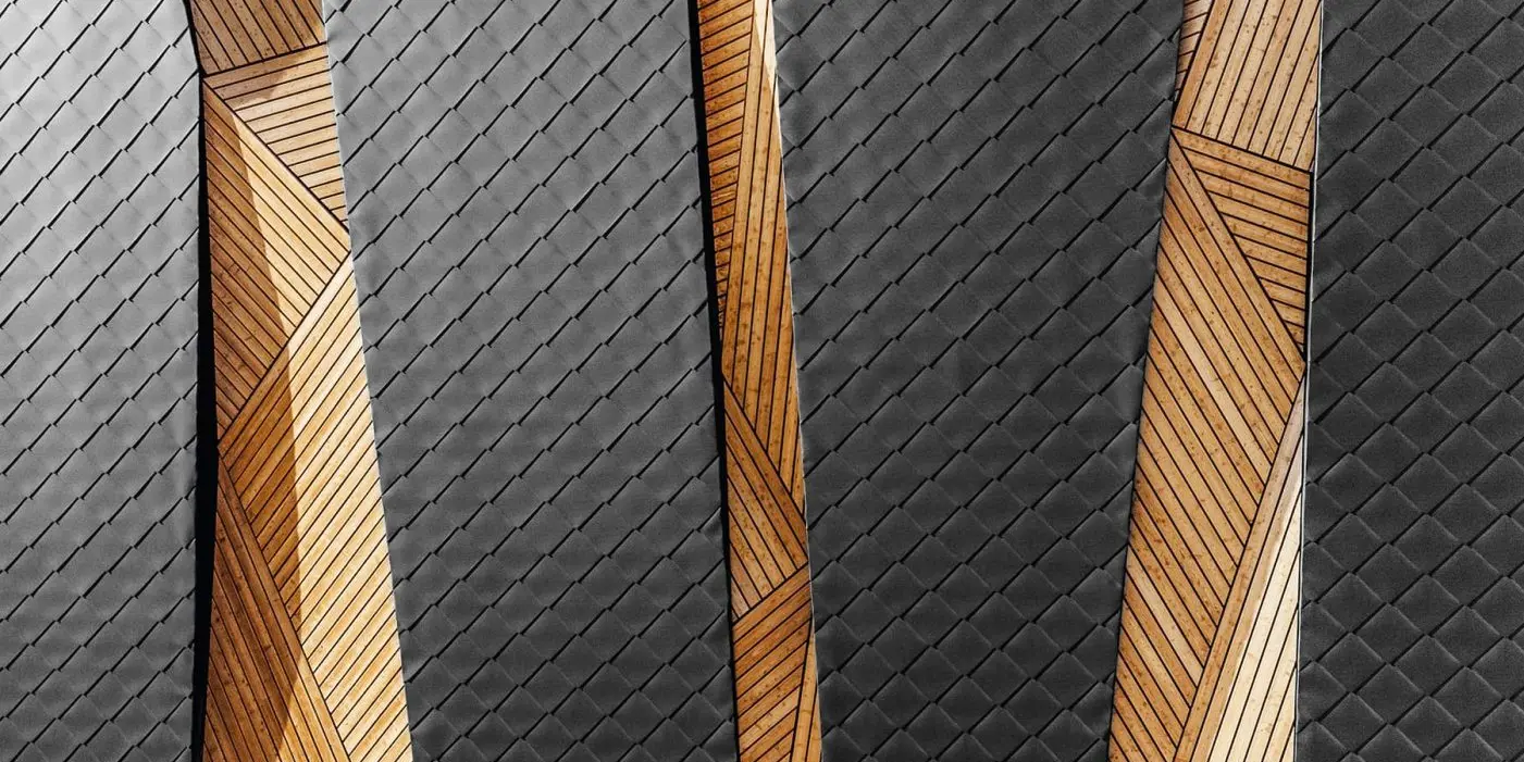 Close-up of PREFA Rhomboid façade tile 44 × 44 in a modern combination with wood.