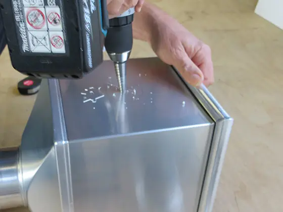 How to create a DIY emergency overflow in a PREFA leader head — Step 2: Pre-drill hole.
