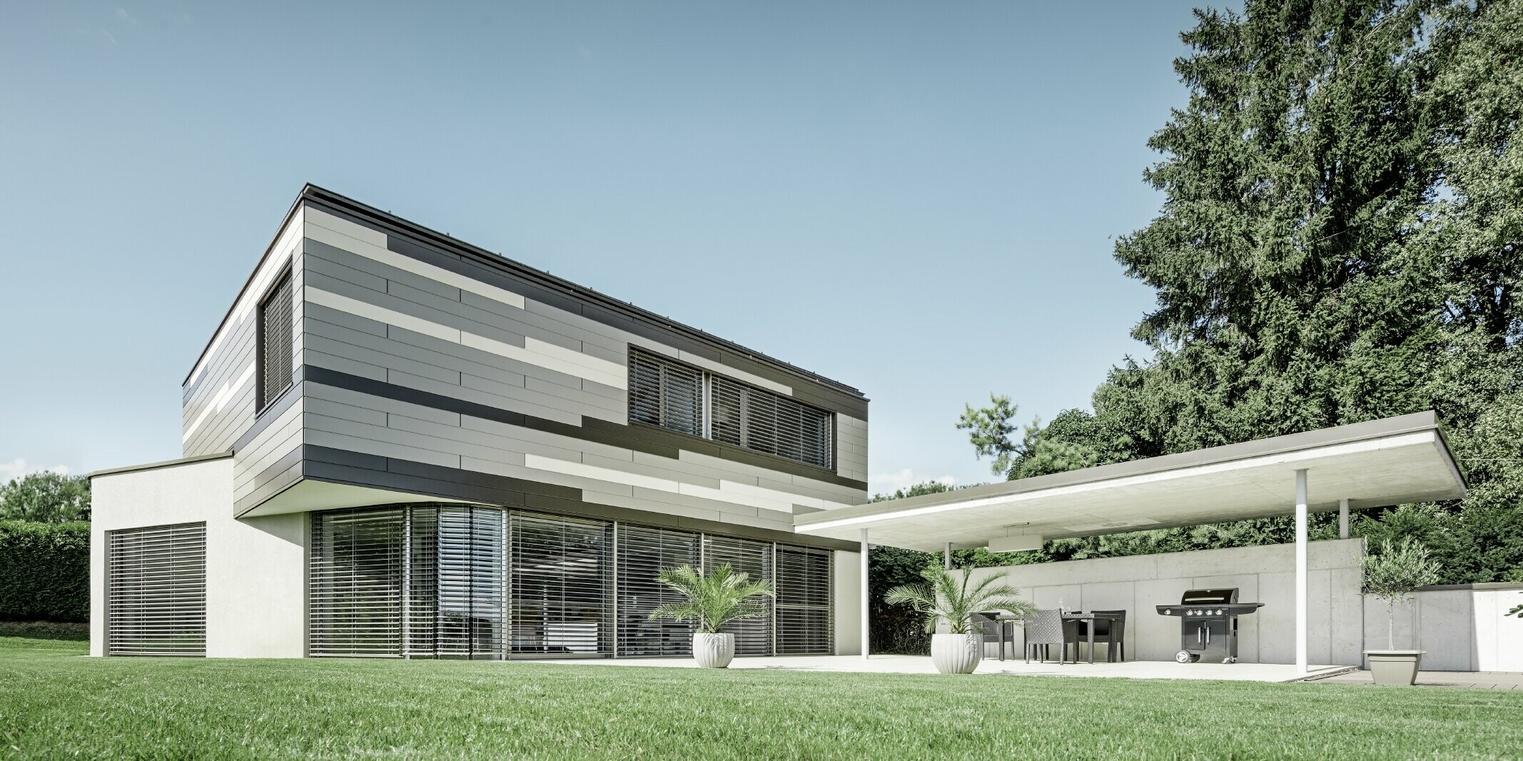 Modern detached house with a flat roof and covered terrace with an individually designed PREFA aluminium façade made of sidings in brown, bronze and ivory