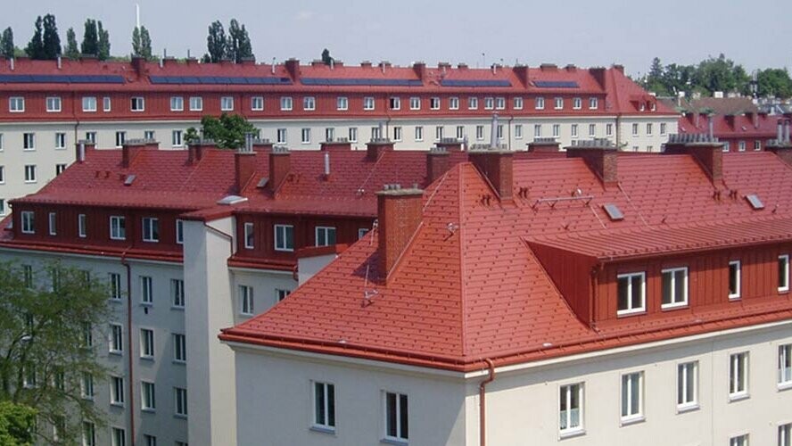 Picture of residential buildings at Hugo Breitner Court in Vienna. These roofs were covered with PREFA shingles in brick red.