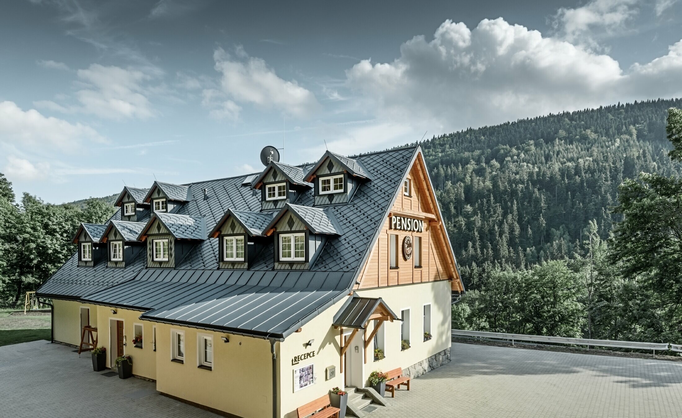 Guesthouse in the Czech Republic with pitched roof and many dormers covered with aluminium roof from PREFA, scaly rhomboid roof with snow guard system