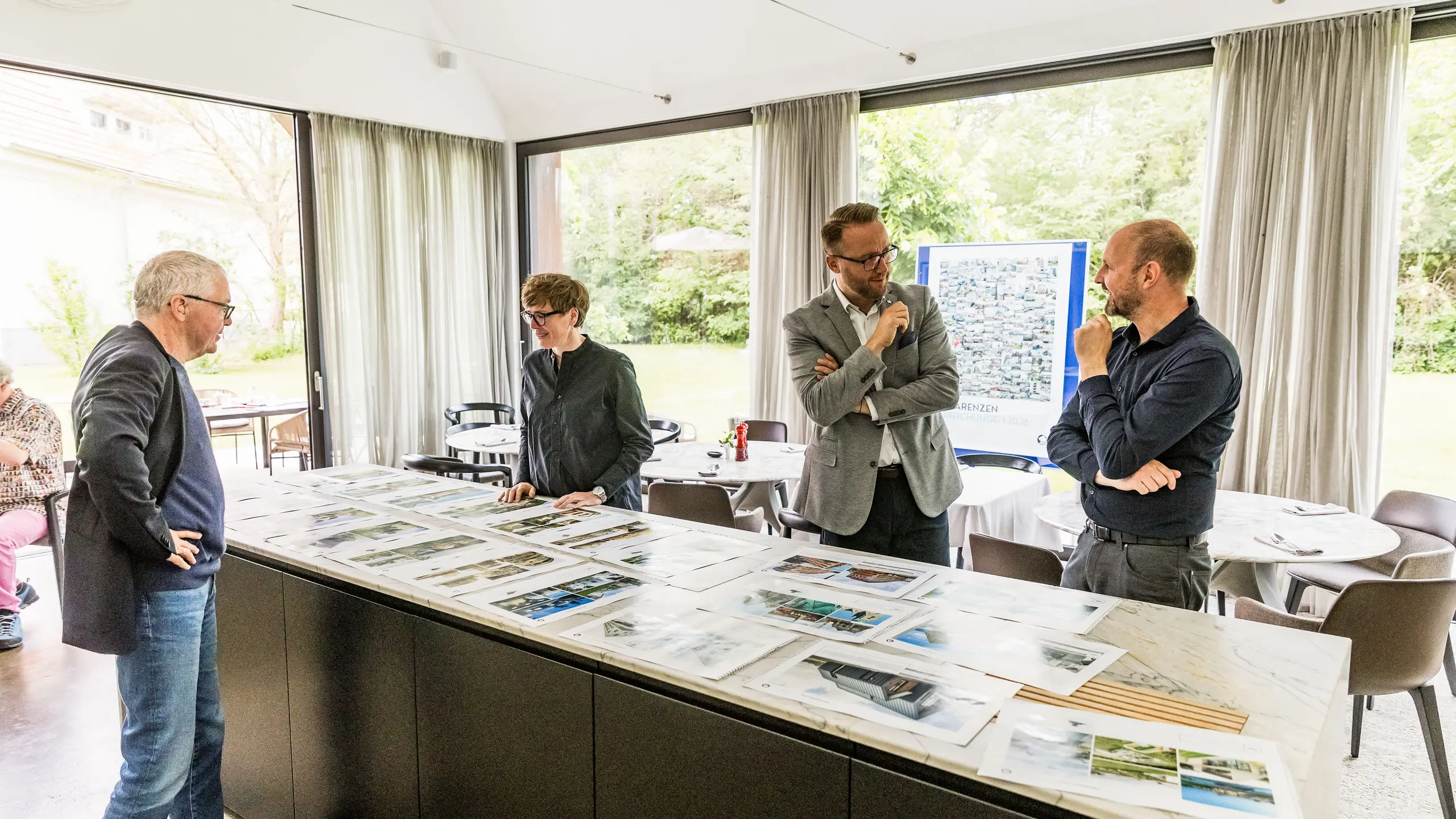 The final selection of PREFARENZEN architectural highlights for 2026 is available in large images from parts of the high-calibre jury. The experts carefully examine the submitted architectural projects for their innovative strength, design quality and use of PREFA materials. The meeting in the light-flooded winegrower's residence in Seewinkel, Burgenland, marks the conclusion of the intensive jury process for the PREFARENZEN architecture book and the 2026 calendar.