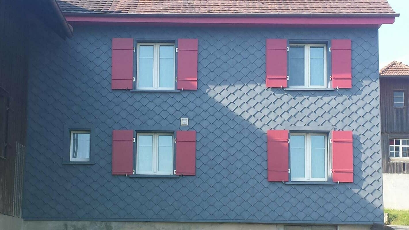 Renovation of façade with PREFA rhomboid façade tiles and four windows with red shutters