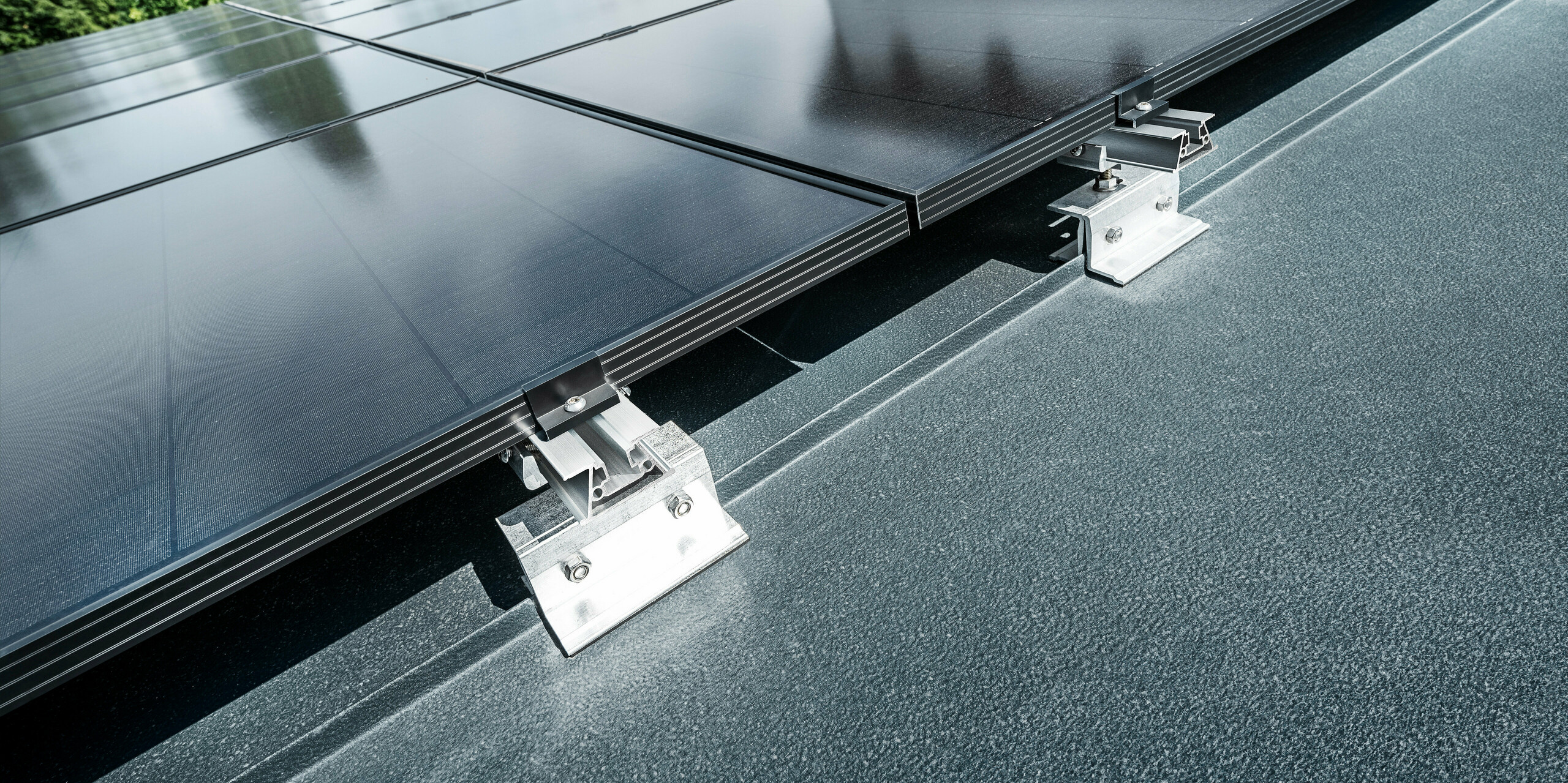 Close-up of the Vario PREFALZ solar bracket on a standing seam roof in anthracite 