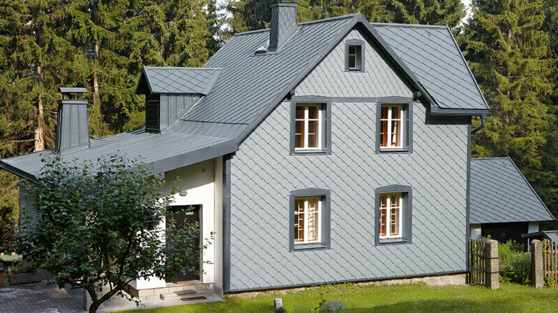 Detached house in a wooded area with a weather-resistant PREFA aluminium façade in light grey.