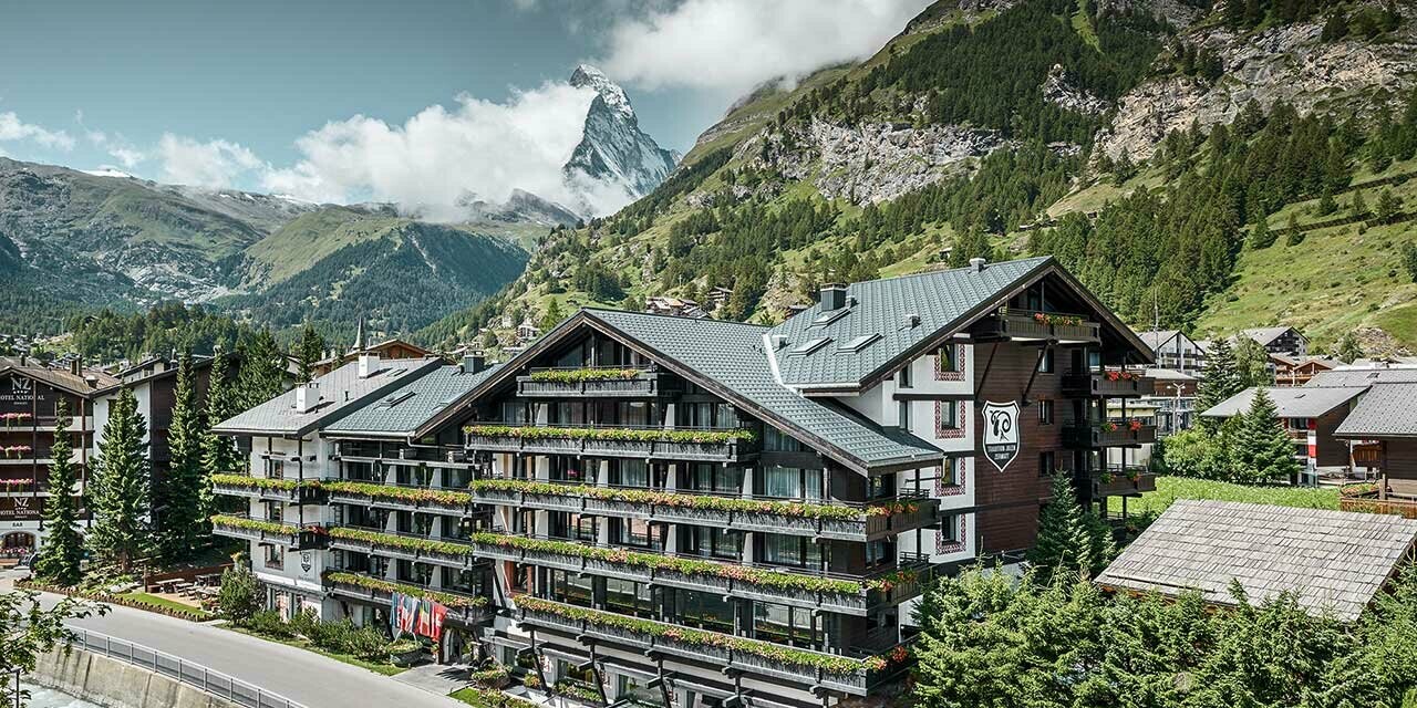 Hotel Alpenhof in Zermatt (Switzerland) with the Matterhorn mountain in the background, balconies, dark wooden façades and a PREFA aluminium roof in anthracite