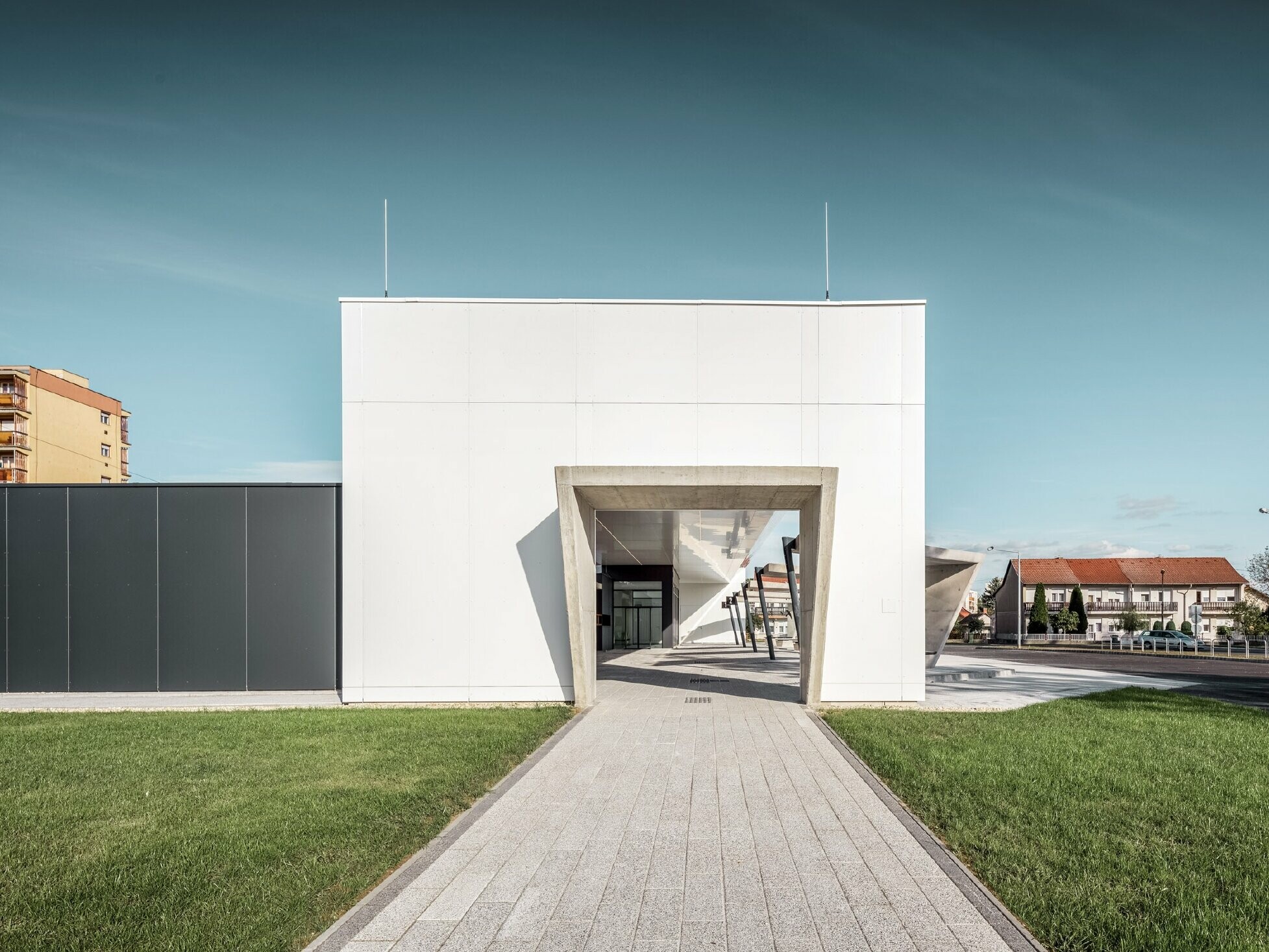 Lateral view of the railway station in Lenti, Hungary. A passageway to the bus stops is visible.