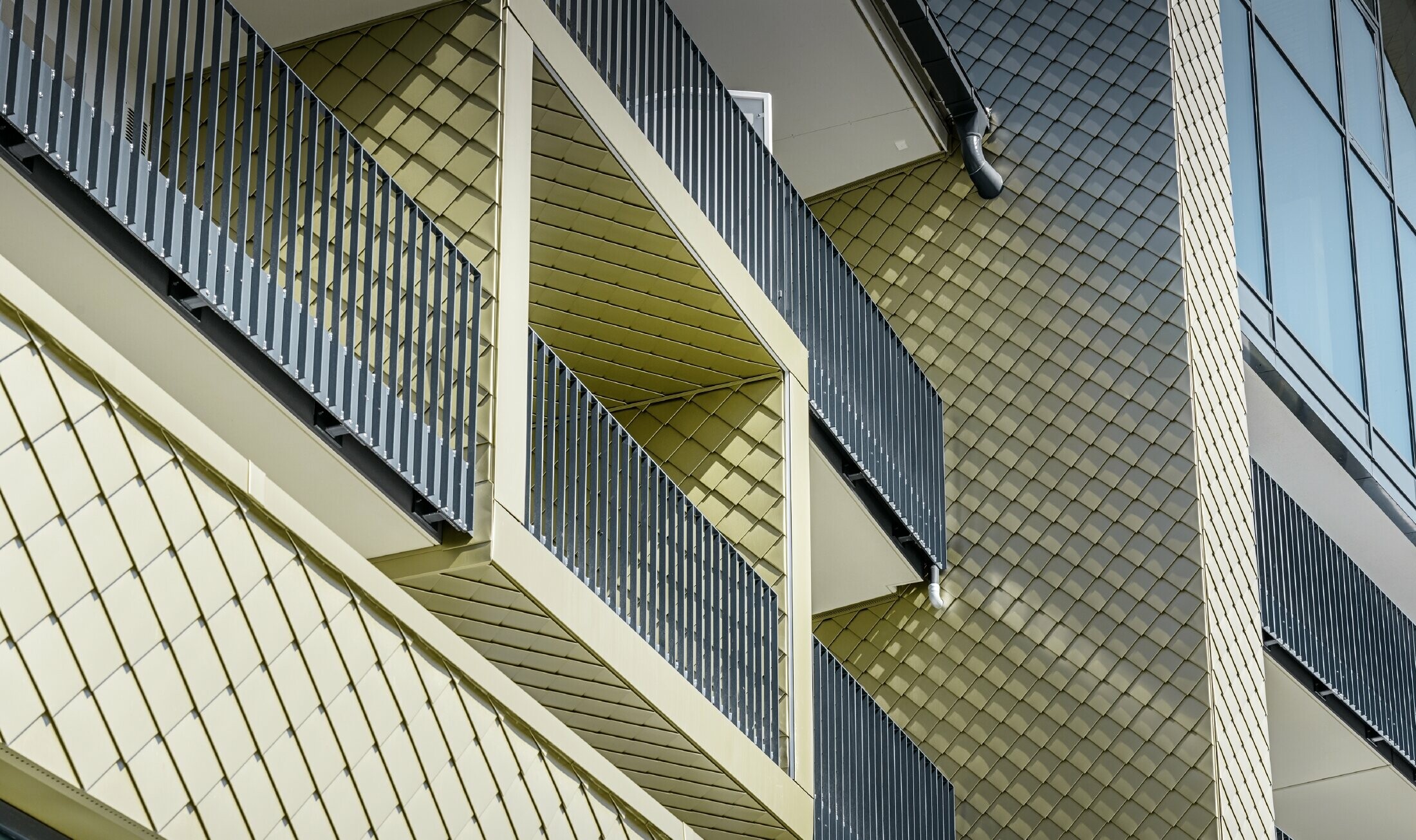 Cladding of the balcony surrounds at Hotel Edita in Scheidegg with the PREFA 20 x 20 rhomboid façade tile in light bronze
