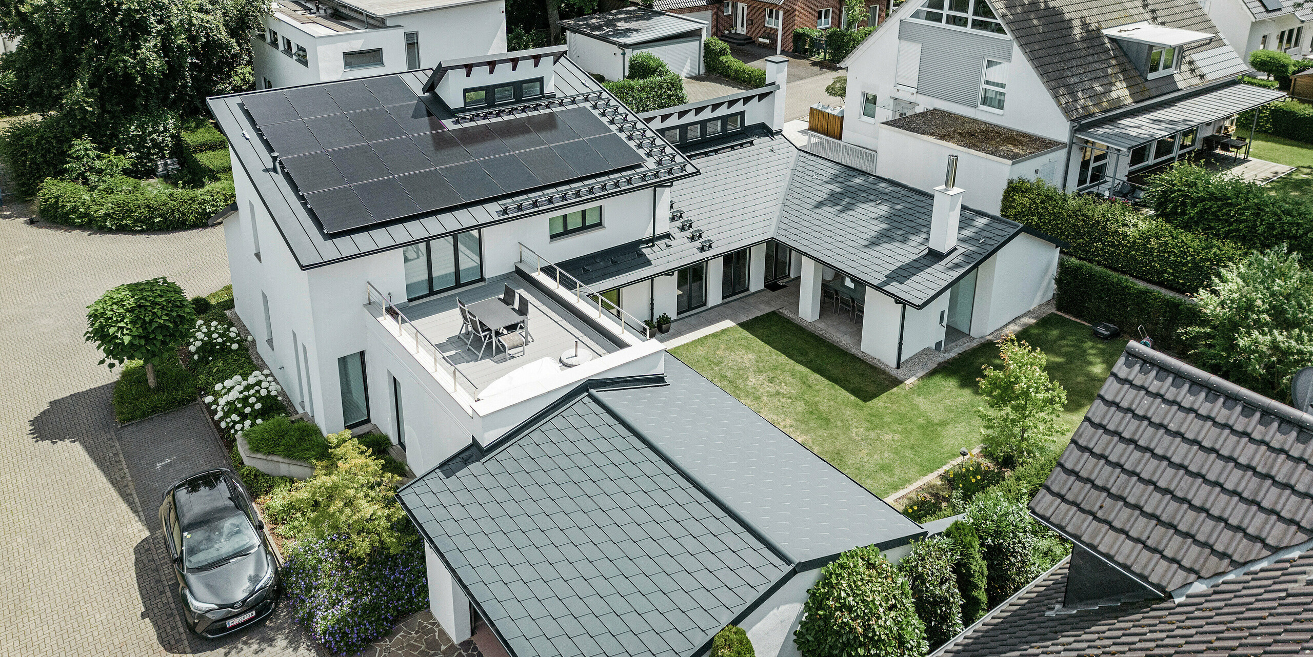 Bird's eye view of the outstanding roof landscape of a detached house in Dortmund with PREFA roof shingles DS.19 and PREFALZ in P.10 anthracite as well as a large-scale PV system