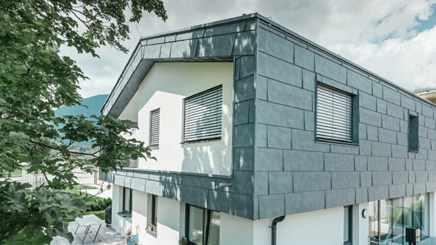The first floor of a modern residential building clad with PREFA aluminium FX.12 aluminium façade panels in the colour stone grey.