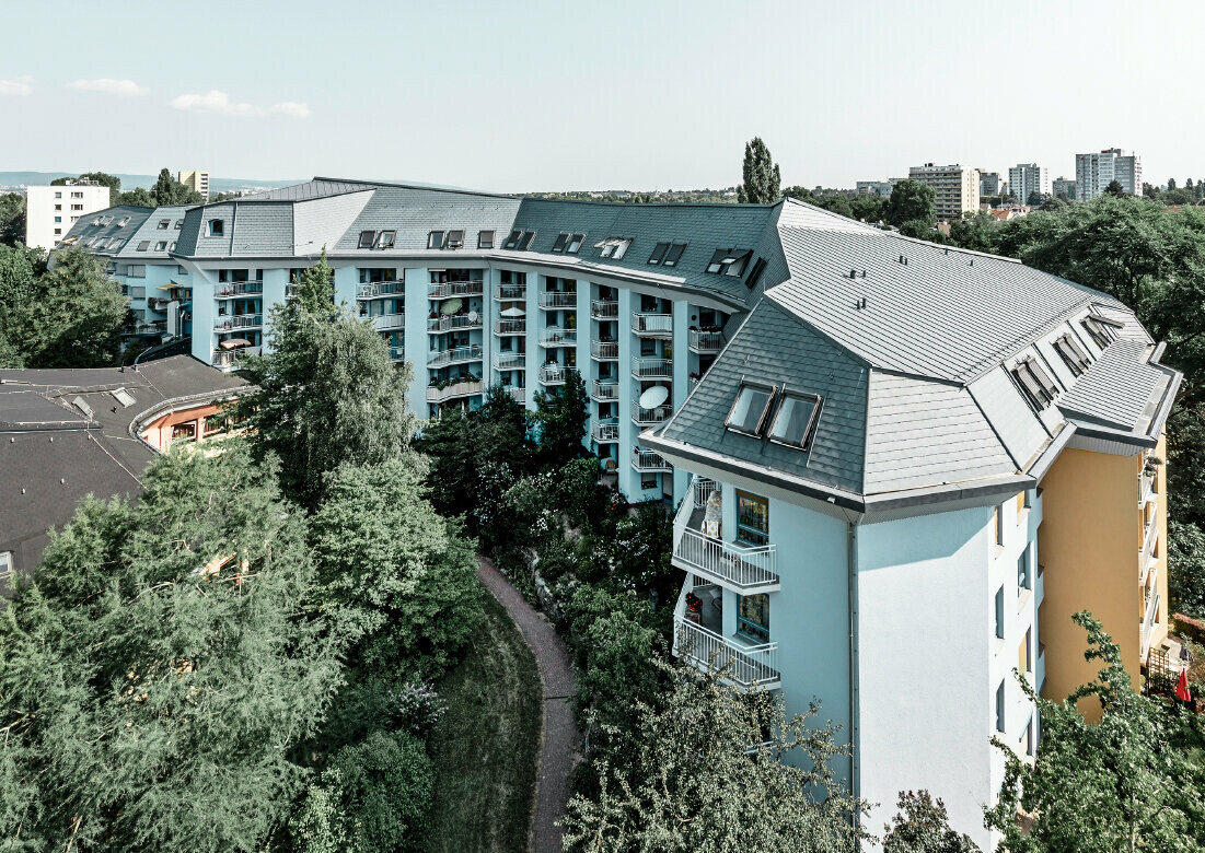 Large aged-care facility covered with the PREFA roof shingles and Prefalz in stone grey with numerous balconies.