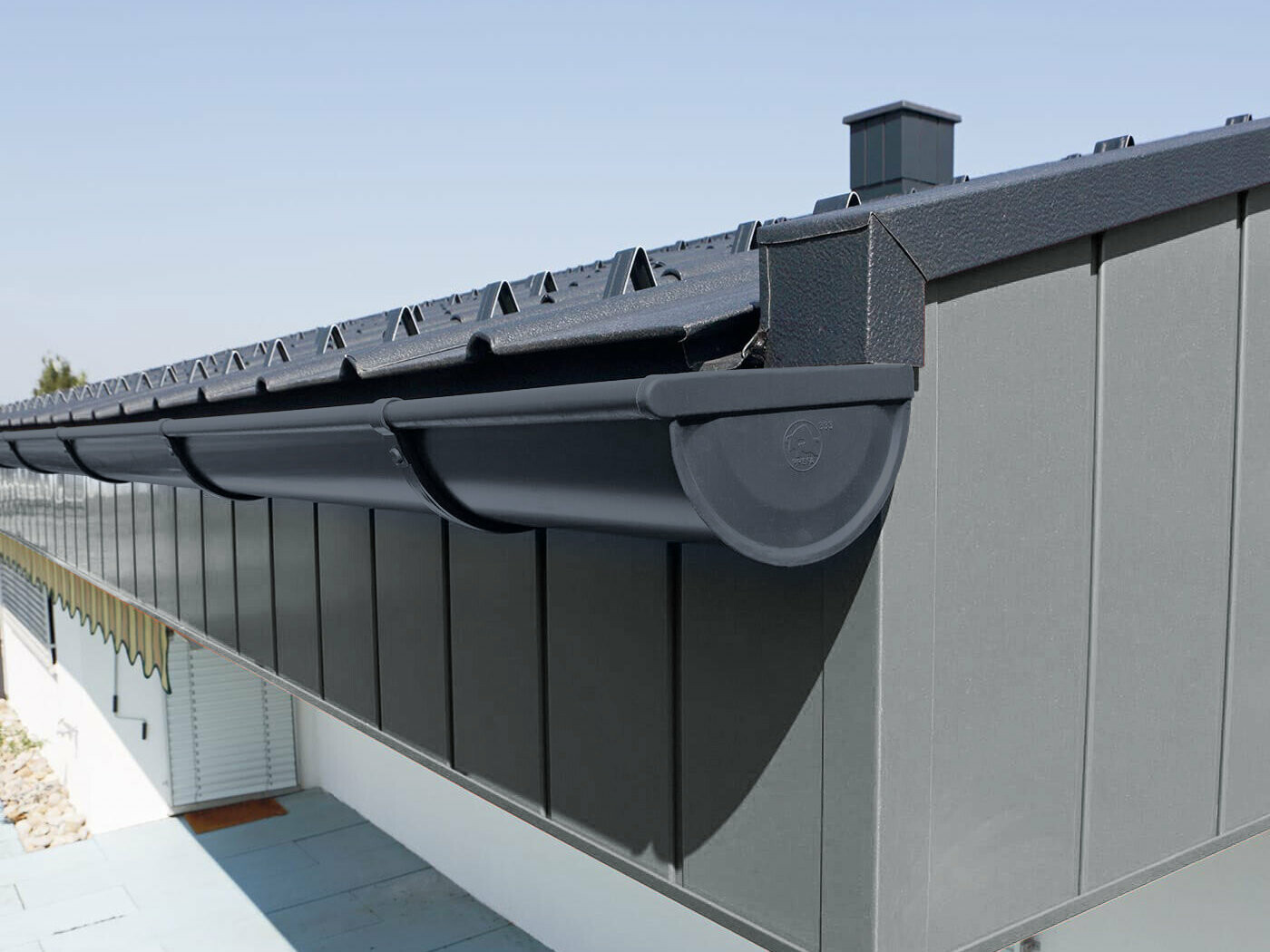 PREFA half-round gutter with gutter brackets in anthracite, the upper section of the façade is clad with PREFA sidings.