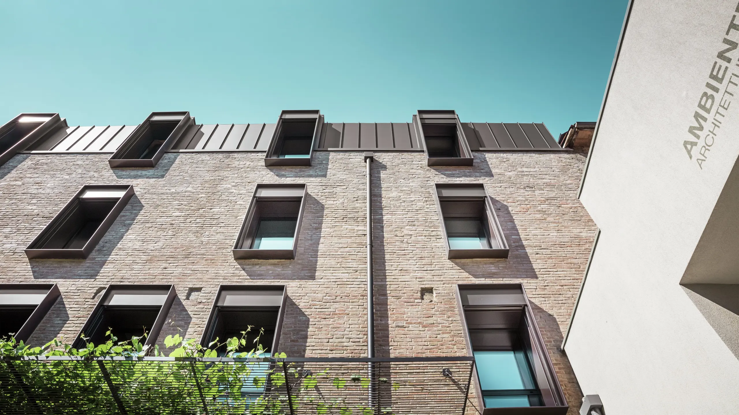 Traditionelles Backsteinhaus in Italien mit langlebigem PREFALZ Aluminiumdach in der Farbe P.10 Nussbraun – harmonische Kombination aus mediterraner Architektur und moderner Dachlösung