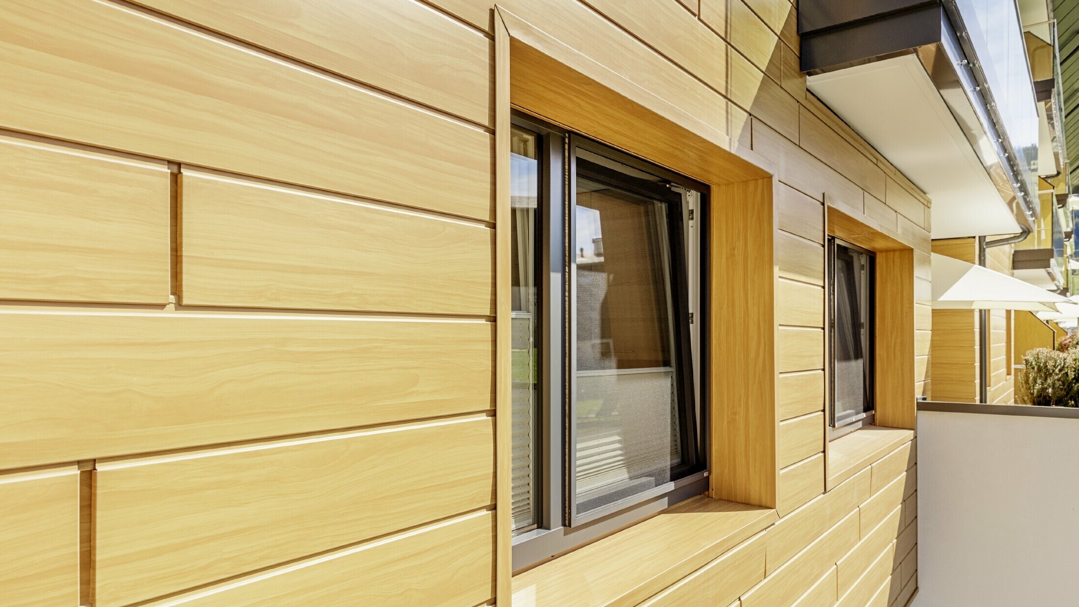 Detailed close up of a window surround with PREFA sidings in a wood finish at the Guthof Lutz in Schattwald.