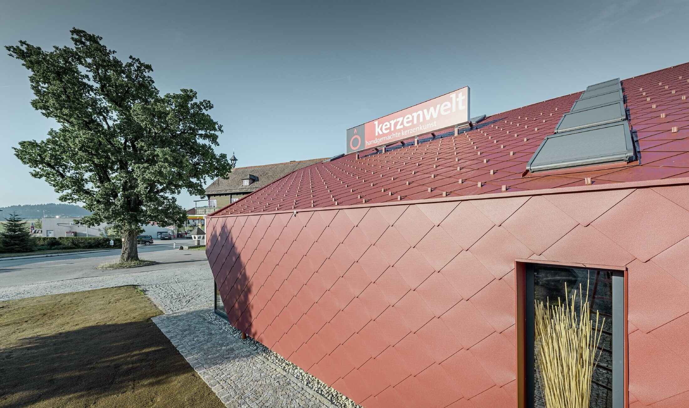 The Kerzenwelt candle store in Schlägl was completely reclad in the PREFA rhomboid tile. The 44 × 44 rhomboid façade tile in oxide red was used for the roof cover and the façade cladding.
