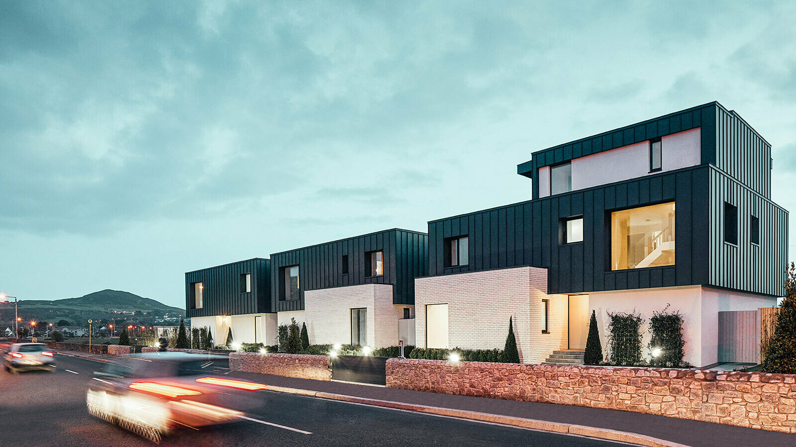 A picture of the three terraced houses in dust. Cars are passing by the houses.