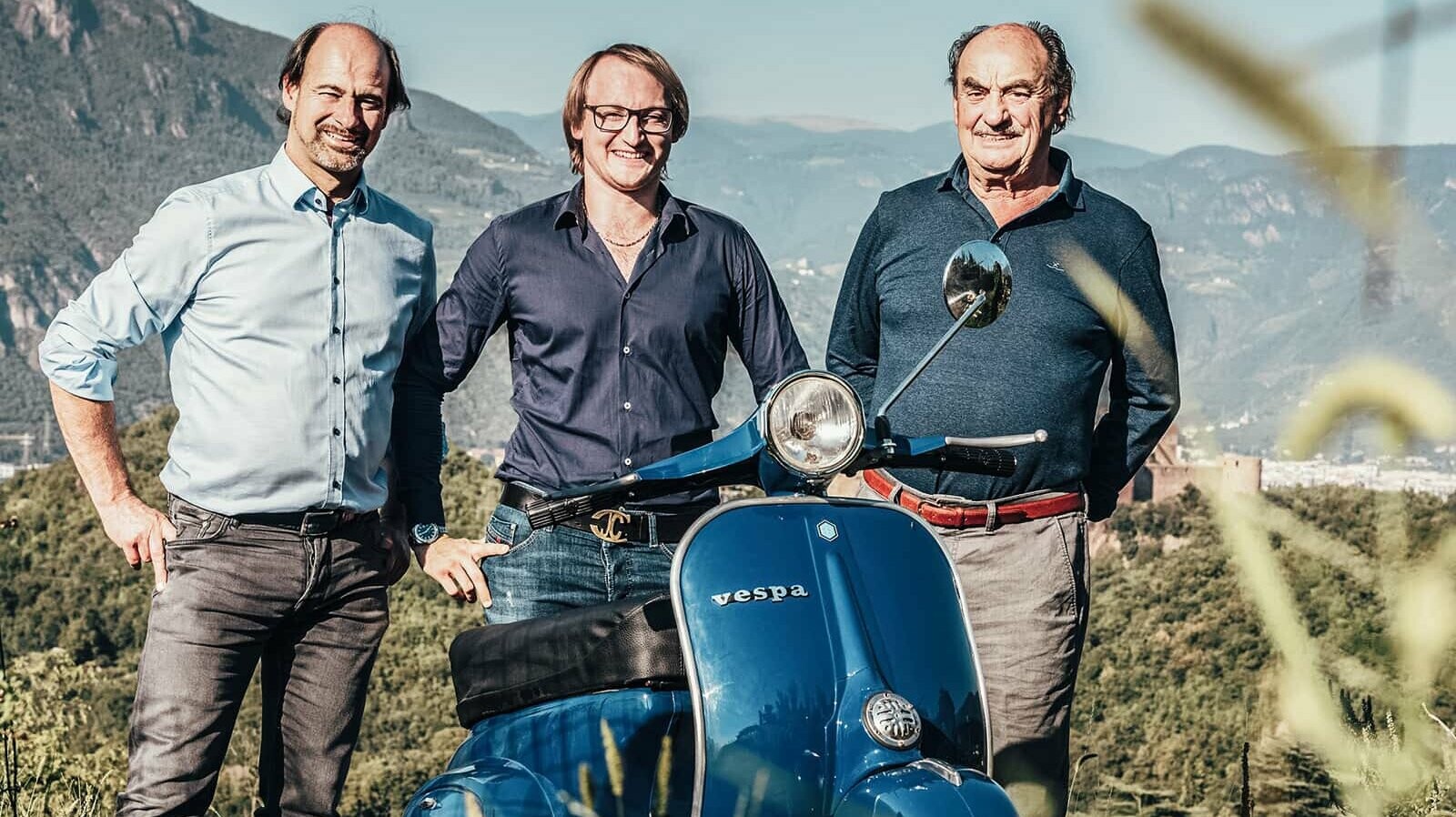 The 3 hotel professionals of the team from Planstudio Pedereiva. A blue Vespa can be seen in the foreground.