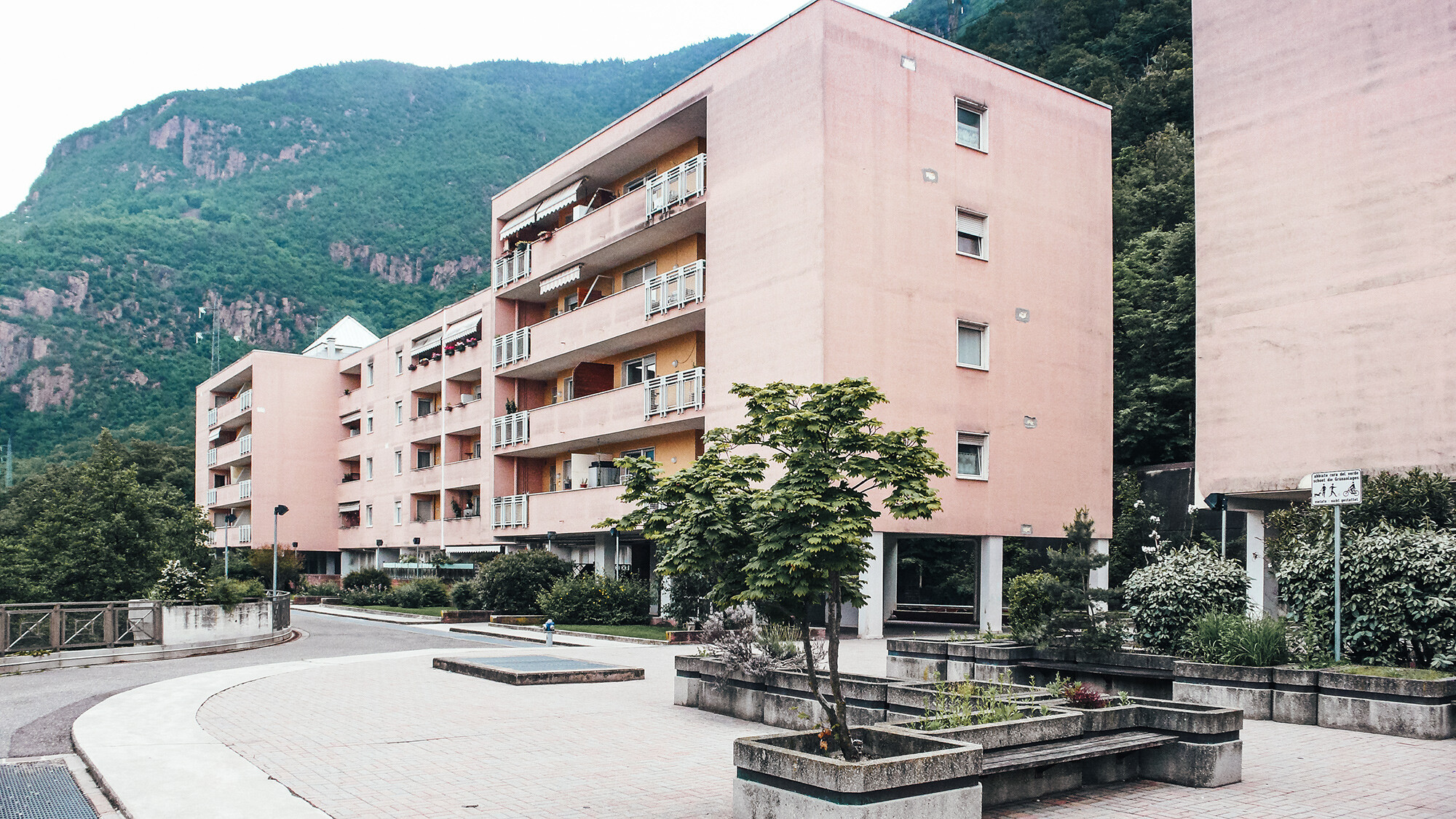 Before photo of the project on Köstenweg: a salmon-coloured, outdated concrete building.