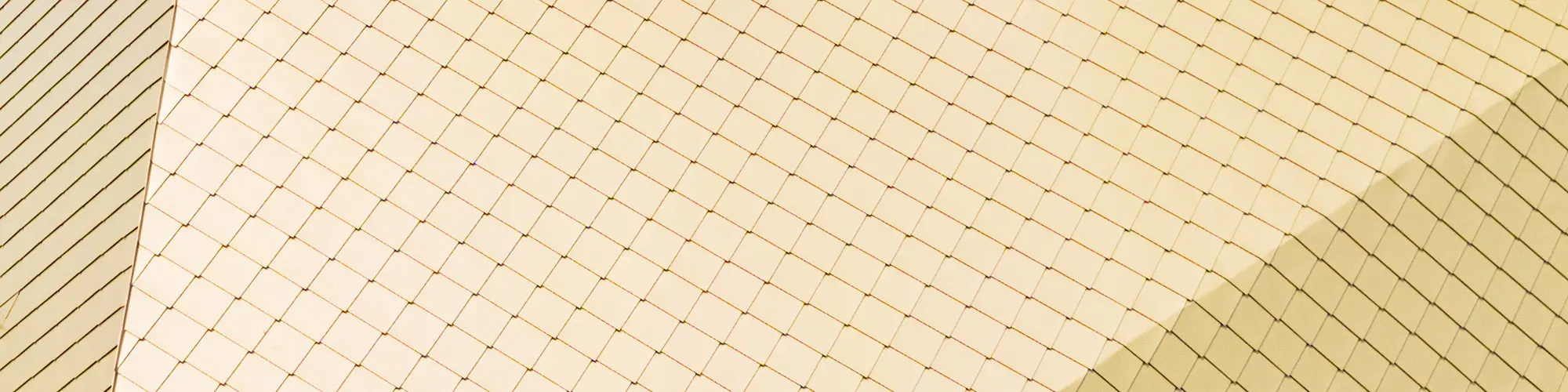 The multiply folded aluminium roof with the gold shimmering rhomboid tiles from up close.