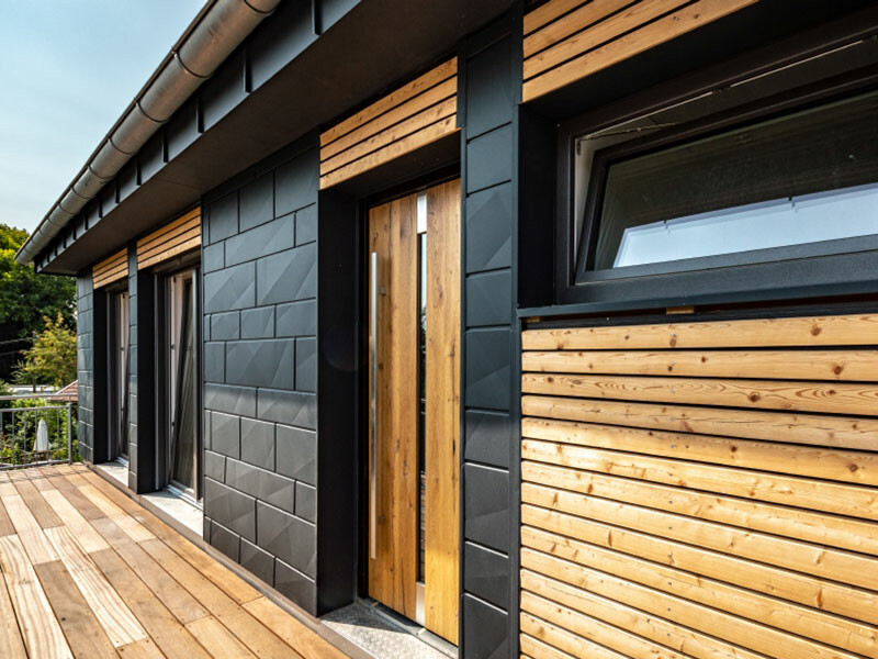 Modern detached house with beautiful PREFA Siding.X façade panels in anthracite and wooden elements.