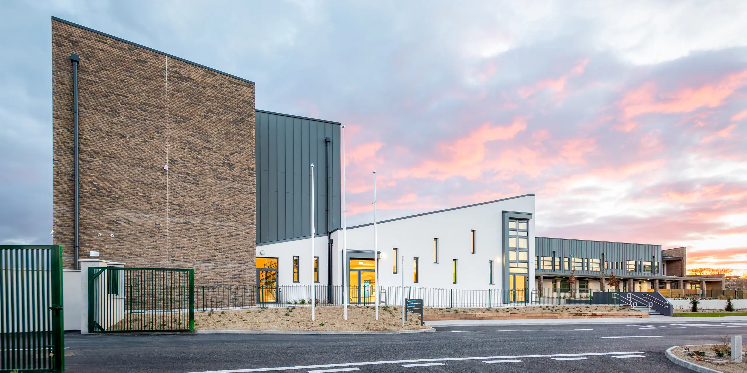 The modern school building of Scoil Mhuire Naofa in Carrigtwohill, Republic of Ireland, features a striking aluminium façade made of PREFALZ standing seam in P.10 light grey. The durable and weather-resistant standing seam roof covers around 800 m² and combines functionality with timeless aesthetics. The high-quality architecture is particularly effective against the backdrop of a picturesque sunset.
