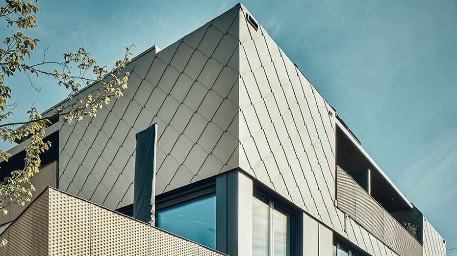 You can see the side view of the residential building, which is clad with PREFA rhomboid façade panels 44x44 in P.10 bronze.