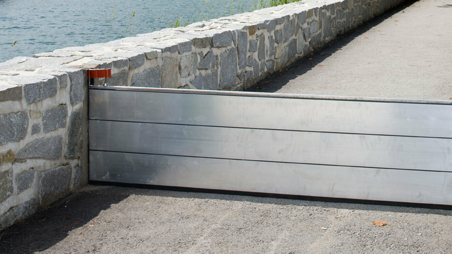 Footpath next to a river with PREFA flood protection