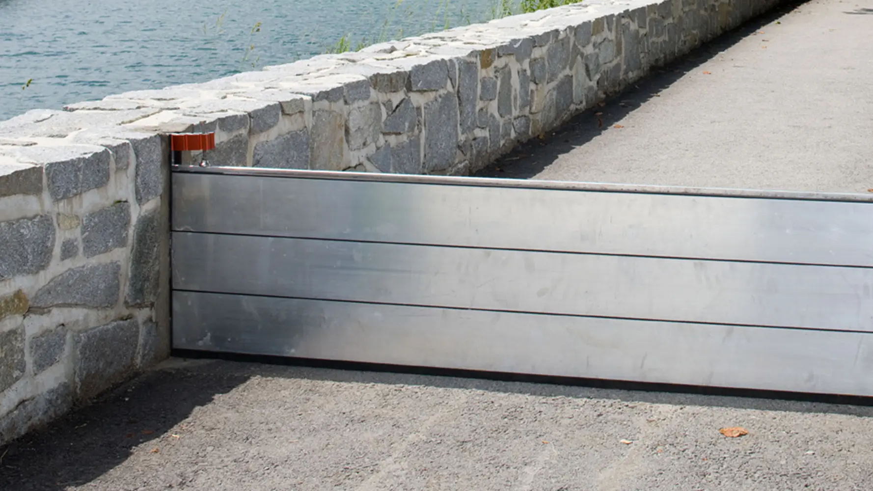 Footpath next to a river with PREFA flood protection