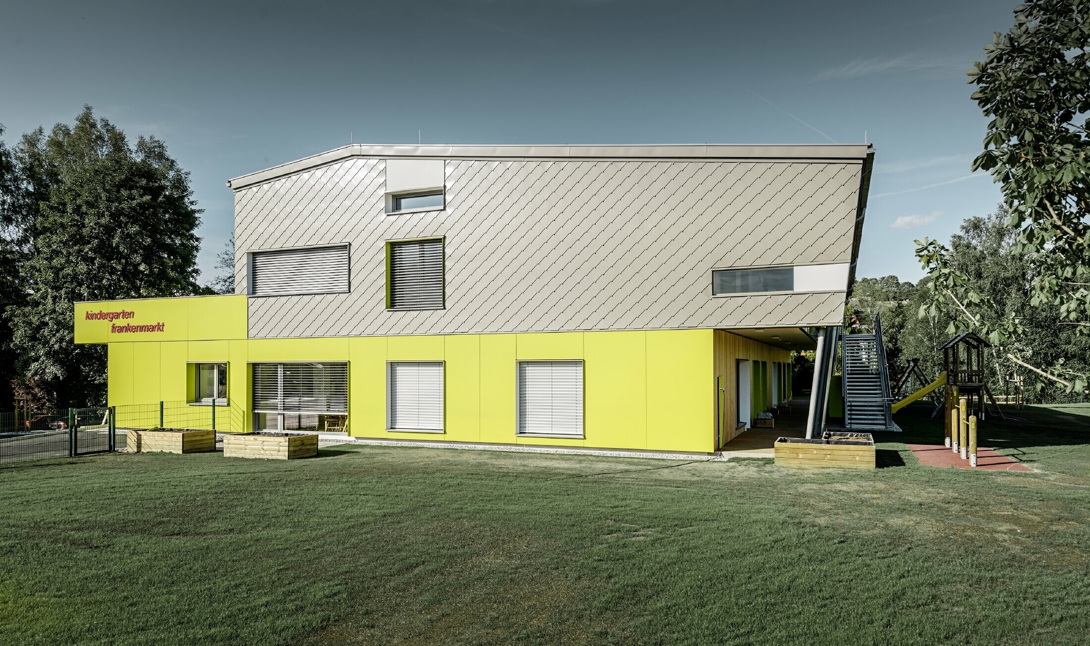 The kindergarten was partially clad in the PREFA 29 rhomboid tile in bronze; this part of the building also does not have a soffit. The rest of the façade was clad in façade tiles in yellow.