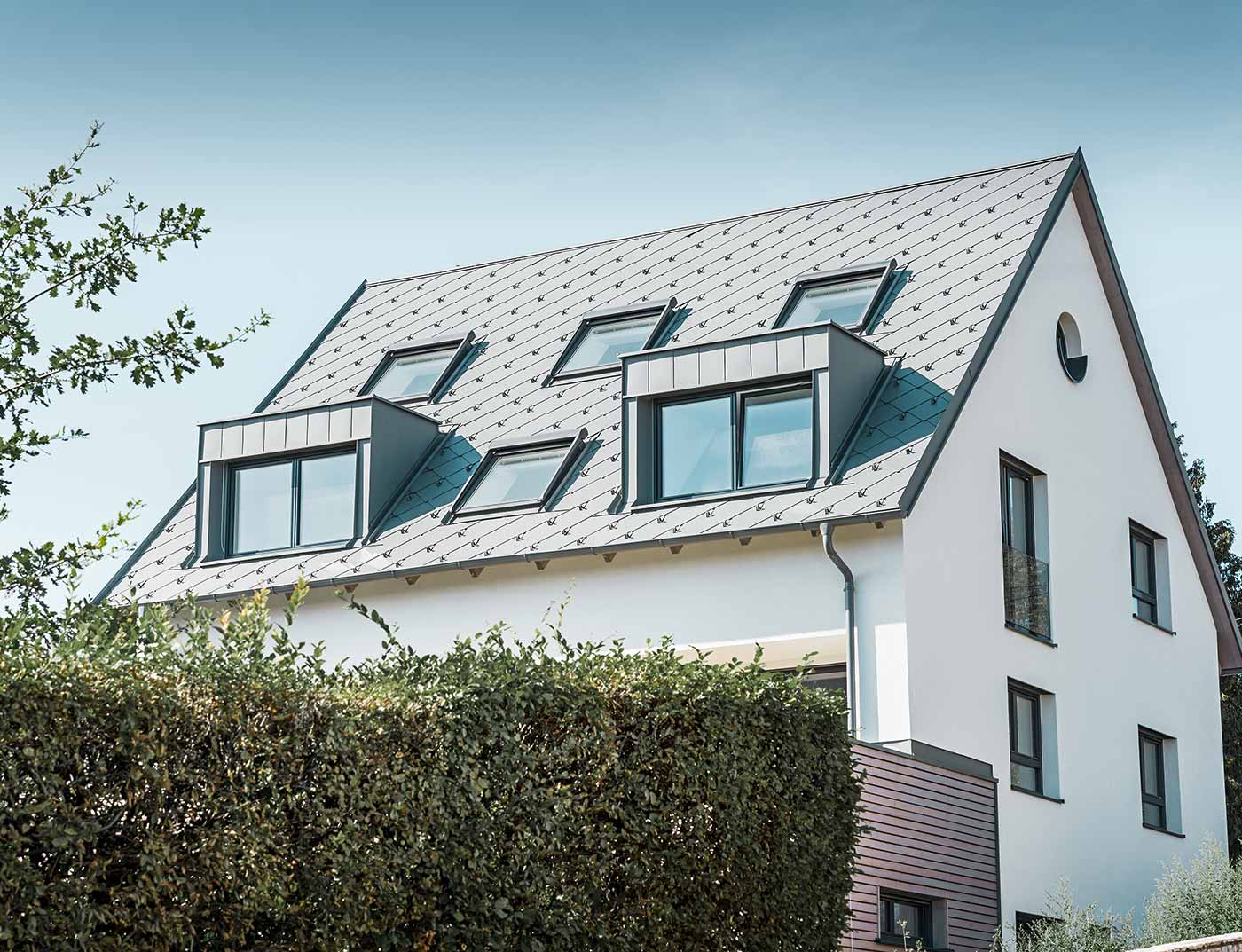 PREFA rhomboid roof tile 44 × 44 light grey reference Classic gable roof with two dormers and several skylights, covered with PREFA light grey 44 × 44 rhomboid roof tiles.